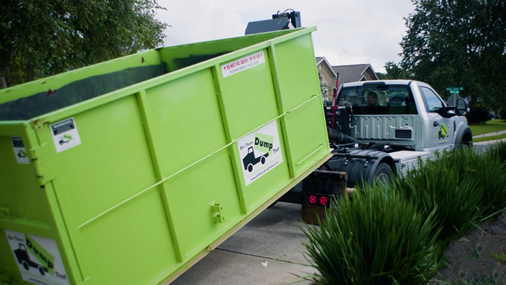 Truck dropping off bin in driveway